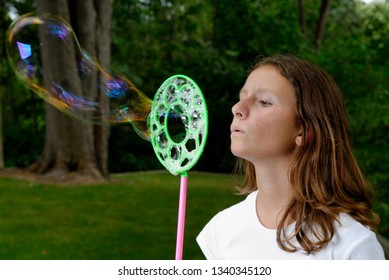 Teenage Girl Blowing Giant Bubble Outside