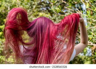 Teenage girl and bright raspberry pink ombre long colored hair  Generation Z styles   trends  View from behind 