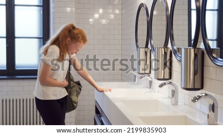 Teenage girl crying in school bathroom. Upset teen student cry in campus toilet having problems at school