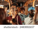 Teenage girl with curly hair standing on a crowded public bus among other passengers.