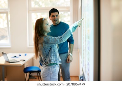 Teenage Girl Doing Assignment On Interactive Whiteboard During A Class At High School.