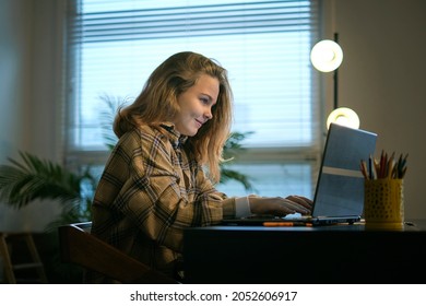 Teenage girl doing homework at a desk in her bedroom. teen girl school student write notes watch video online webinar learn on laptop. distance elearning course video conference pc call. - Shutterstock ID 2052606917