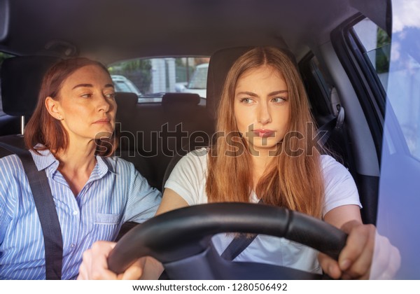 Teenage girl during\
driving lesson in a car