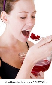 A Teenage Girl Eating Red Jello Or Jelly. Isolated On A White Background.