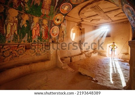 Teenage girl exploring cave church in Rose Valley in Cappadocia Turkey dated back to 10th century