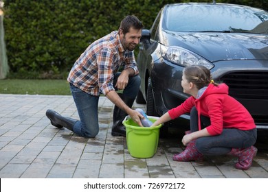 Teenage girl and father washing a car on a sunny day - Powered by Shutterstock