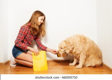 Teenage girl feeding her Golden Retriever doggy - Powered by Shutterstock