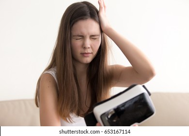 Teenage girl feels dizziness or headache after using virtual reality glasses. Woman suffers from eyes discomfort when took off VR headset. Negative side effect of being in virtual reality. VR sickness - Shutterstock ID 653167114