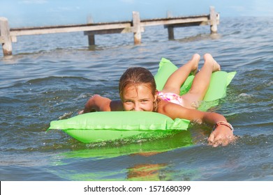 Teenage girl floating on airbed in sea, portrait - Powered by Shutterstock