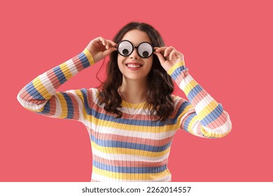 Teenage girl in funny eyeglasses on red background. April Fools' Day celebration - Shutterstock ID 2262014557