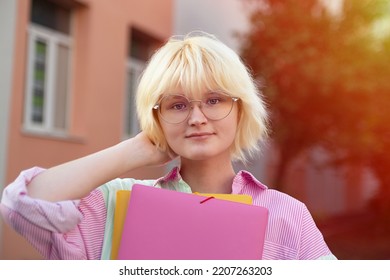 Teenage Girl In Glasses With Colorful Folders Outside.Closeup Portrait,sunlight On Background.