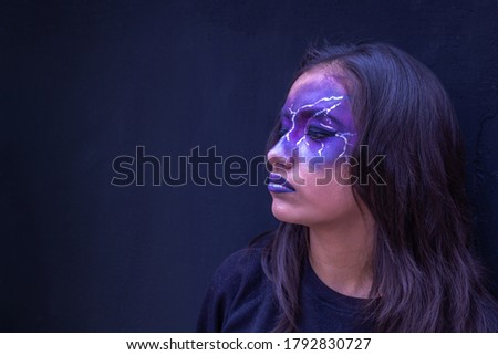 teenage girl with Halloween makeup on a dark background with copy space. Profile pose