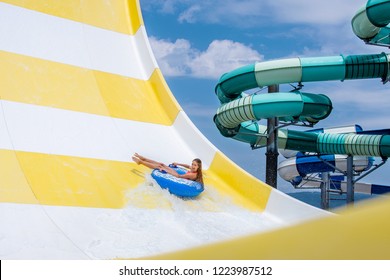 Teenage Girl Have Fun Riding On Inflatable Ring In Water Park 