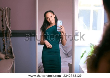 Teenage Girl At Home In Bedroom Getting Ready For Prom Or Night Out Taking Selfie In Mirror