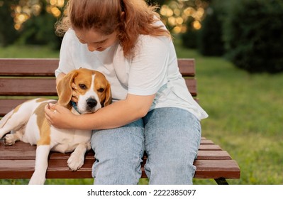 Teenage girl hugging dog on bench, close up - Shutterstock ID 2222385097