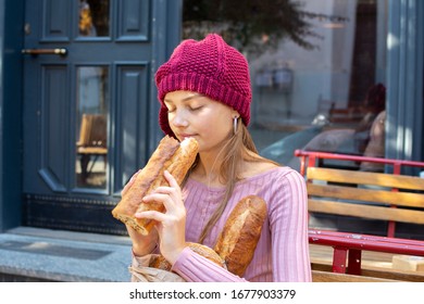 Teenage girl inhales the aroma of freshly baked bread - Shutterstock ID 1677903379