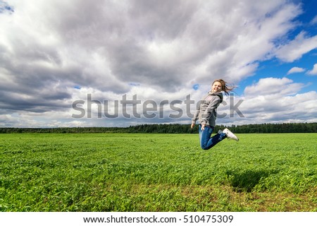 Similar – Junge Frau genießt den Tag auf einem Feld mit Grünflächen.