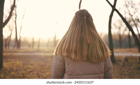 teenage girl long hair walks through forest park in autumn. travel freedom adventure concept. a girl hair in the wind walks through the park in the forest in lifestyle autumn - Powered by Shutterstock