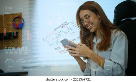 A Teenage Girl Looking At Stock Charts Or Crypto Currency Growth Through A Hologram Screen, She Is Happy To See The Growth Of Cash. Modern Investment Ideas In Stocks Or Crypto-currency.