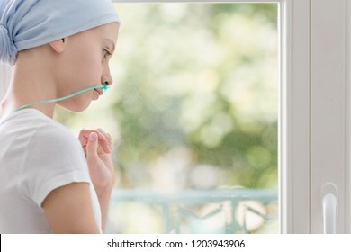 Teenage Girl With Lung Cancer Looking Through The Window In Medical Center