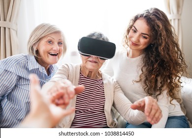 A Teenage Girl, Mother And Grandmother With VR Goggles At Home.