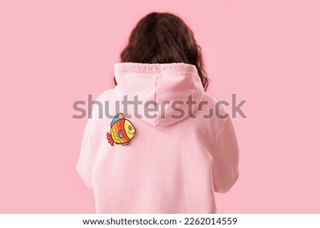 Teenage girl with paper fish on pink background, back view. April Fools' Day celebration Photo stock © 