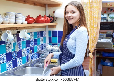 Teenage Girl With Part Time Job Washing Up In Coffee Shop