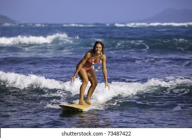 teenage girl in pink bikini surfing in hawaii - Powered by Shutterstock