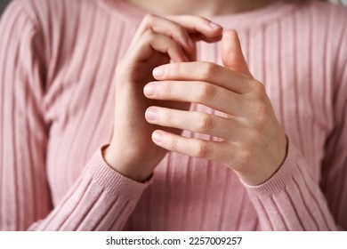 Teenage girl in pink top tapping on the side of the hand acupressure point - practicing EFT or emotional freedom technique - Shutterstock ID 2257009257