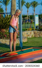 Teenage Girl Play Mini Golf On The Beach