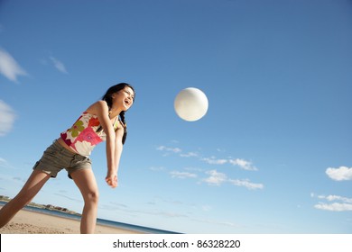 Teenage girl playing beach volleyball - Powered by Shutterstock