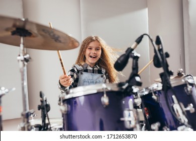 Teenage Girl Playing Drums In Music Studio