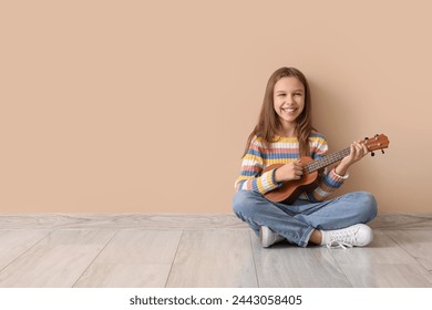 Teenage girl playing ukulele on beige background - Powered by Shutterstock