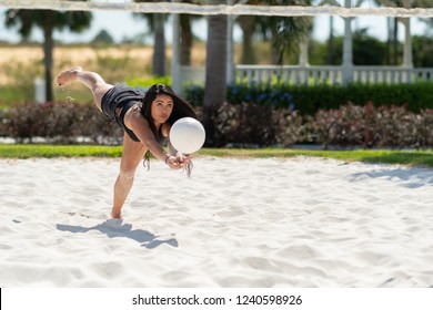 Teenage girl playing volleyball on a sand court