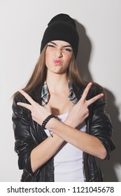 Teenage Girl Posing With Attitude Gesturing Peace With Both Hands Making Pouty Facial Expression. Matte Filter, Studio Lighting, Direct Shadow, Closeup.