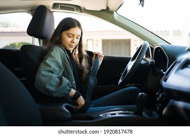 Teenage Girl Putting On Her Safety Seatbelt And About To Start The Car. Teen Driver Getting Ready To Drive Her New Car