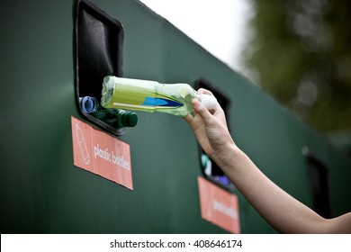 A Teenage Girl Recycling A Plastic Bottle