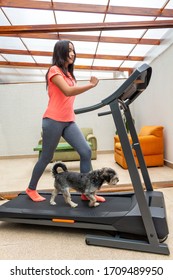 Teenage Girl Running Fun With Her Dog On A Treadmill At Home Due To Quarantine