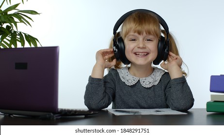 Teenage Girl School Student Wearing Wireless Headphones Calling To Teacher On Laptop. Distance Education Learning At Home. Teen Schoolgirl Chatting By Web Cam Preparing For Test Or Exam