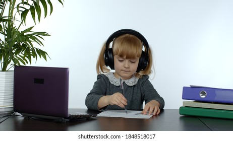 Teenage Girl School Student Wearing Wireless Headphones Calling To Teacher On Laptop. Distance Education Learning At Home. Teen Schoolgirl Chatting By Web Cam Preparing For Test Or Exam