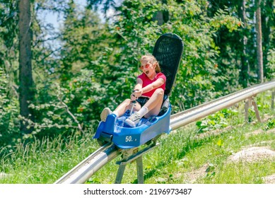 Teenage girl screams going down a mountain roller coaster