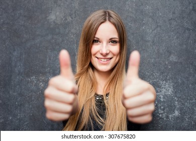 Teenage girl showing thumbs up with both hands