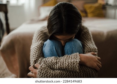 Teenage girl sitting on the floor with head on her knees, koncept of mental health. - Powered by Shutterstock