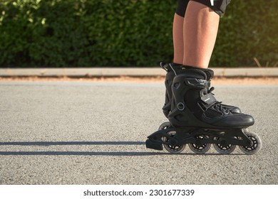 Teenage girl skating wih rollerskates in the street in summer. Skating is low-impact exercise that provides an excellent cardiovascular workout and reduces the risk of osteoporosis