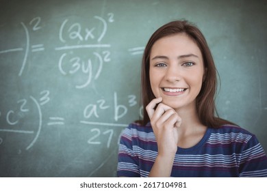 Teenage girl student standing in classroom, with large chalkboard of math formulas, copy space. Education, learning, back to school, academic, equations, handwritten, striped