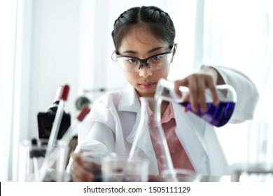 Teenage Girl Students Learning And Doing A Chemical Experiment And Holding Test Tube In Hands In Science Class On The Table.Education Concept