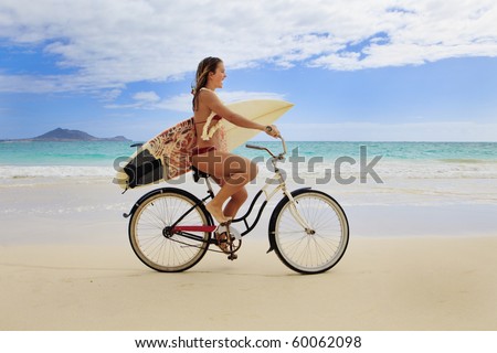 teenage girl with surfboard and bicycle on kailua beach