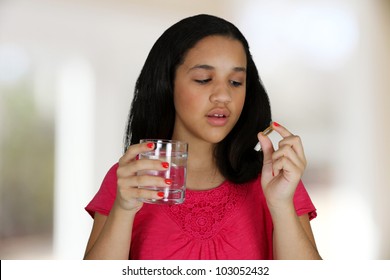 Teenage Girl Taking A Pill At Her Home