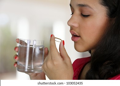 Teenage Girl Taking A Pill At Her Home