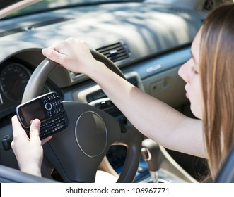 Teenage girl texting on cell phone while driving